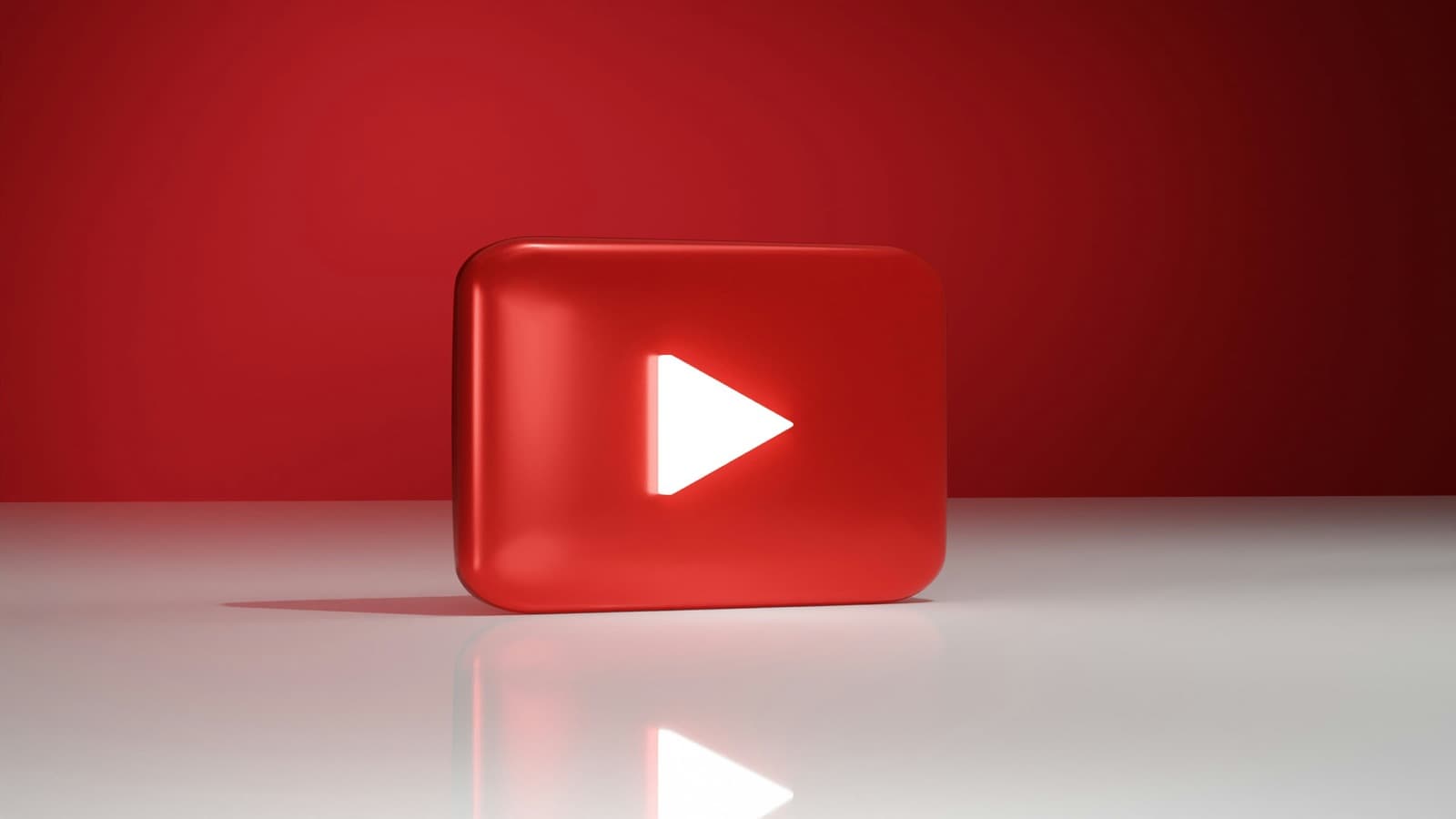 Three-dimensional red YouTube play button on a red background