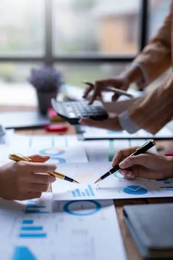 Business team collaborating on project with documents and charts on table