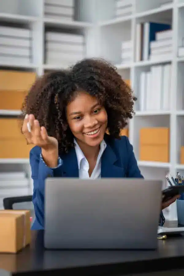 Young African American businesswoman waving at laptop during video call in office