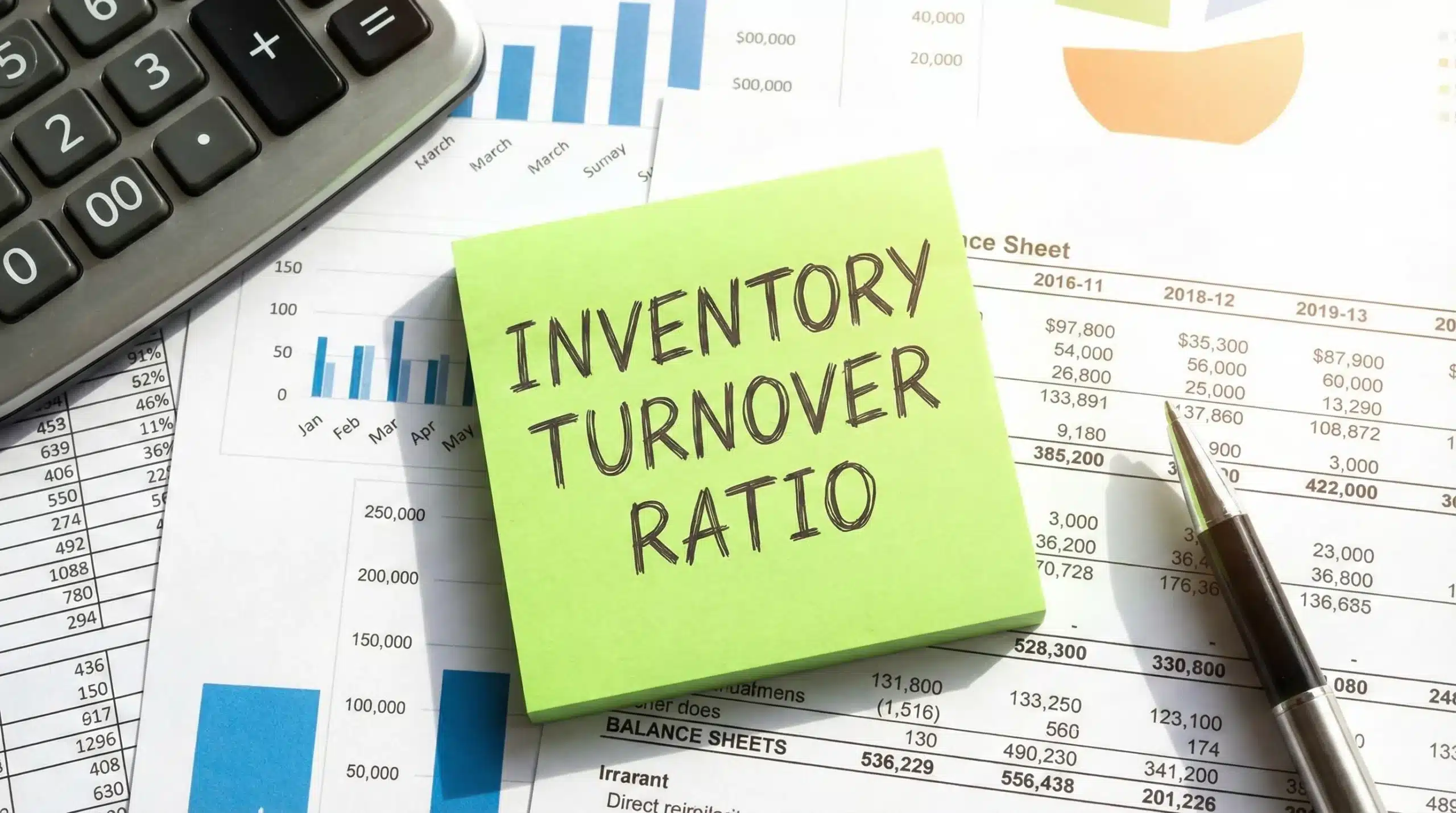 Inventory turnover ratio written on green sticky note with financial documents and charts