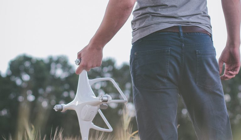 man holding drone in field