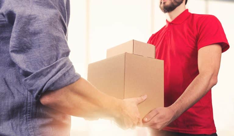 man handing boxes to another man