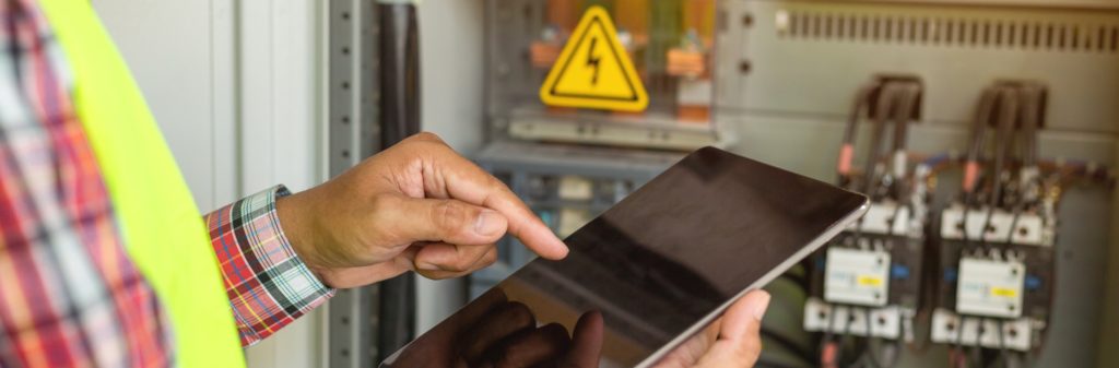 worker with tablet checking electric output