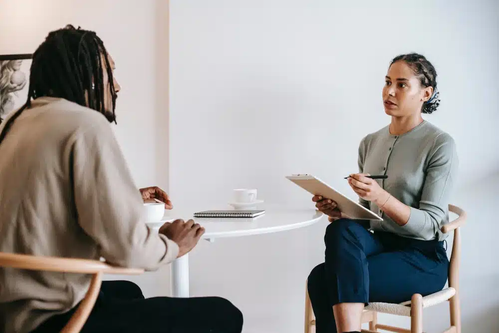 woman holding clipboard while interviewing a man