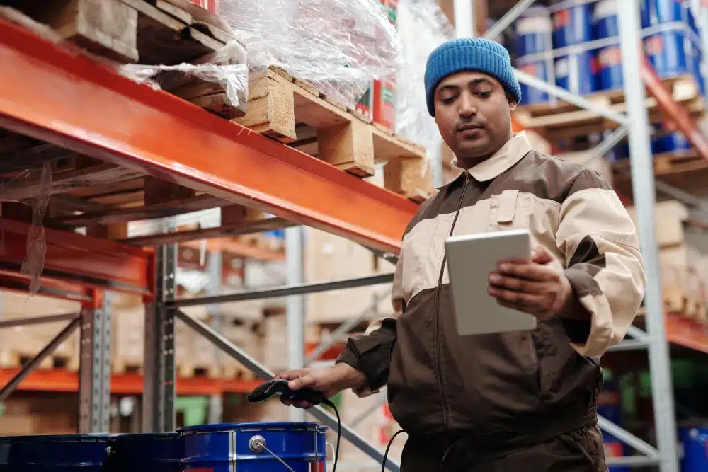 warehouse worker scanning items and viewing data on a mobile tablet