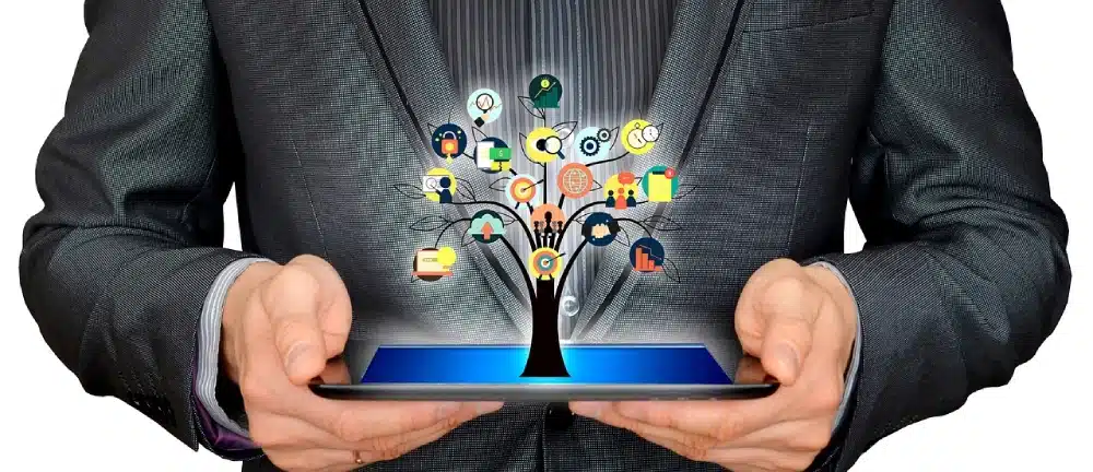 person holding a tablet with an artistic rendering of accounting icons on a tree