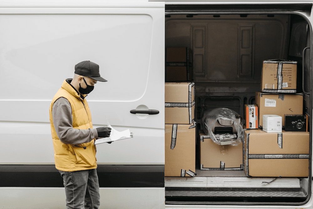 delivery driver outside of van reviewing bill of lading