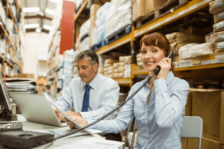 woman using office phone in a warehouse