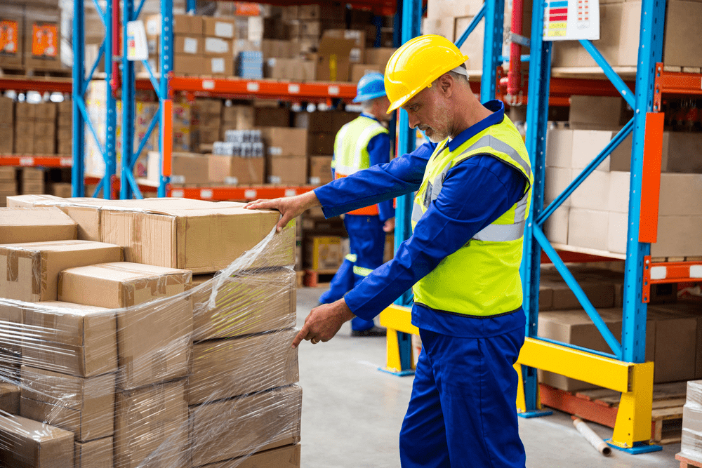 warehouse worker counting boxes on a pallet