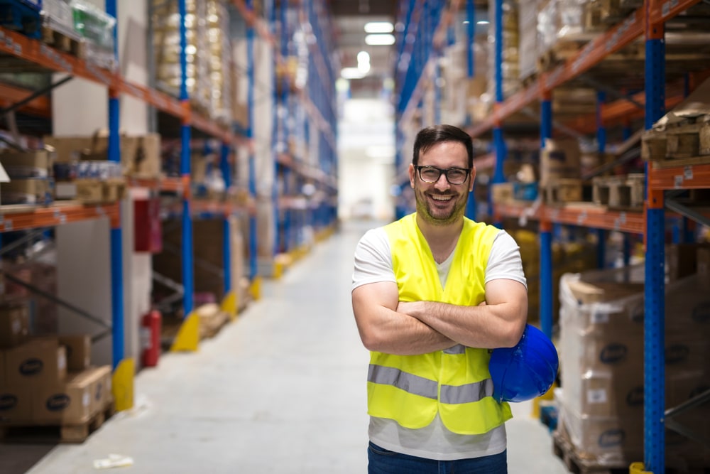 Portrait,Of,Middle,Aged,Caucasian,Warehouse,Worker,Standing,In,Large warehouse worker smiling
