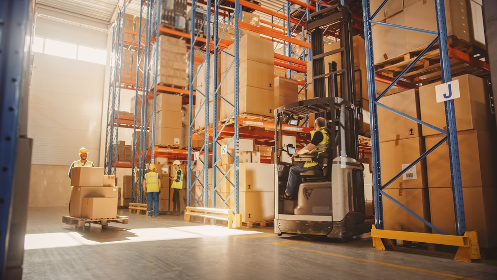 warehouse workers picking items for shipment, forklift in motion