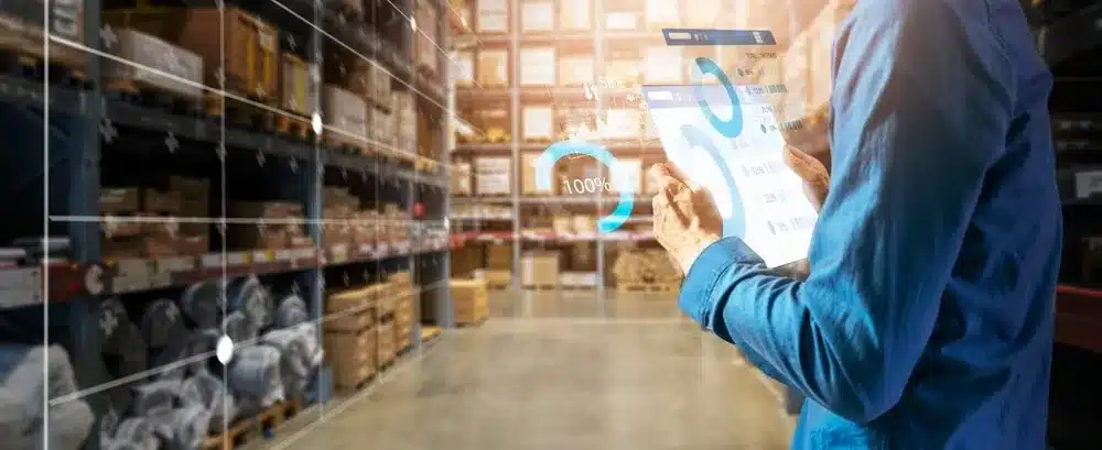 Warehouse manager analyzing digital inventory turnover data on tablet in storage facility